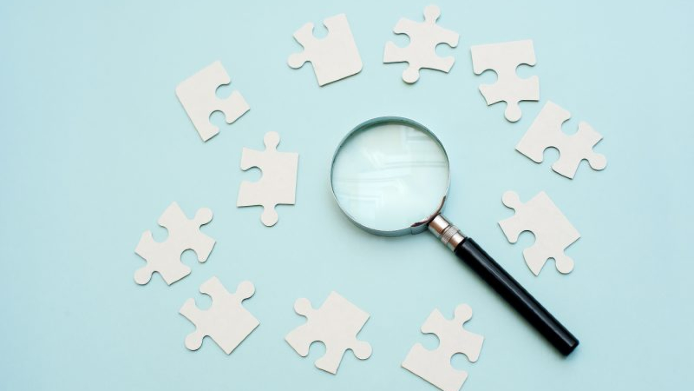 magnifying-glass-white-puzzle-blue-background