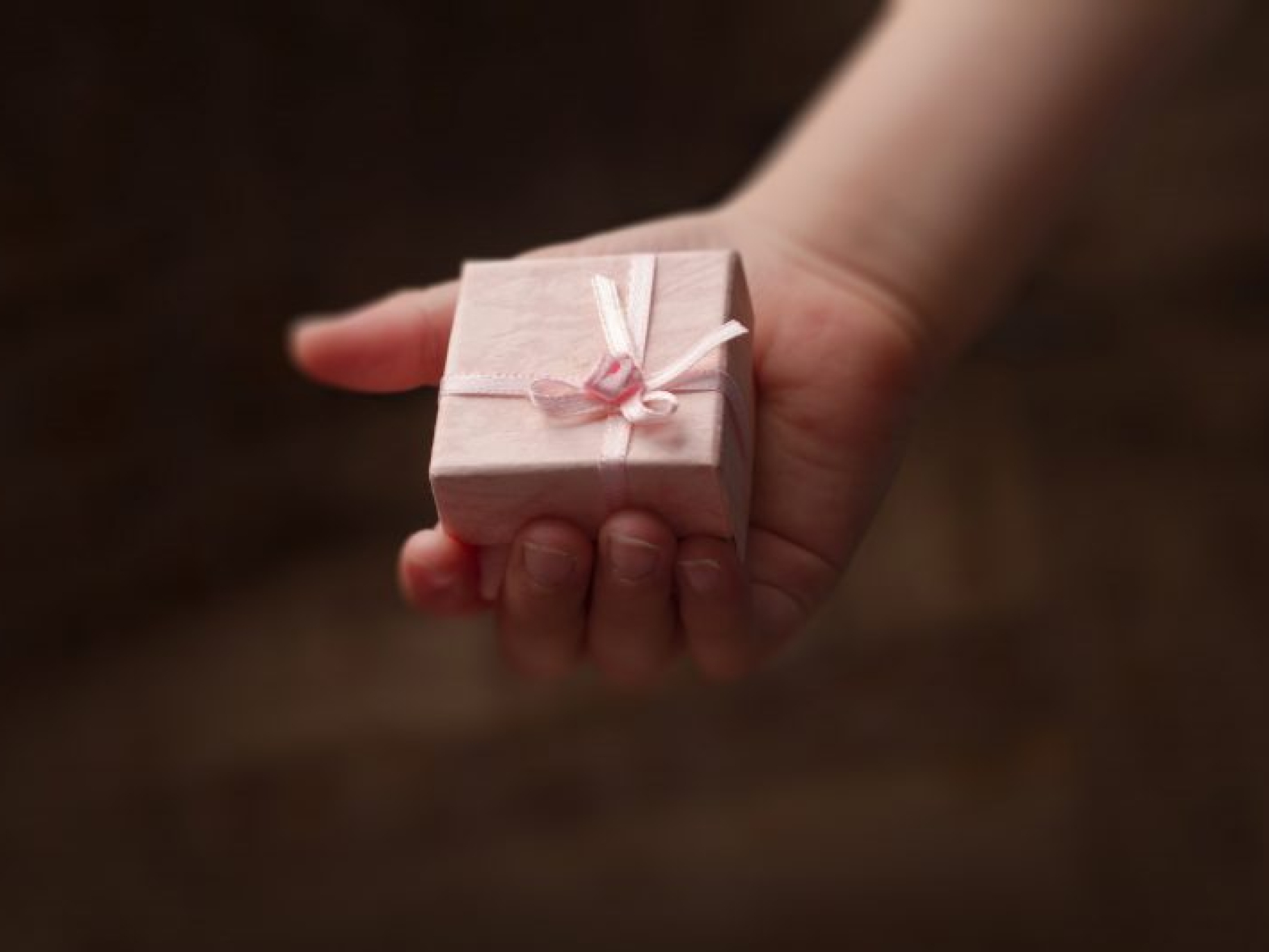 mengembangkandiri.com hand-of-child-holding-a-small-pink-gift-box-2021-08-26-17-04-34-utc